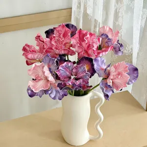 Detail view of oil-painting style artificial Iris flowers in a white ceramic vase