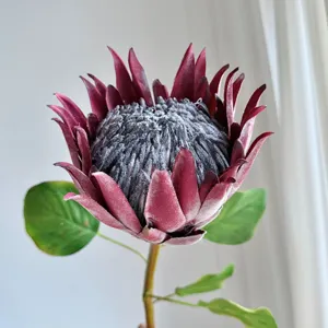Close-up detail of realistic burgundy artificial King Protea flower for home decor