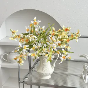 Detailed view of artificial cymbidium flowers in an embossed white ceramic vase