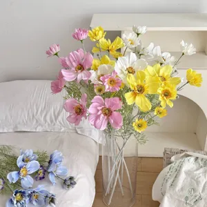 Detailed view of multi-colored artificial cosmos flowers in a clear glass vase
