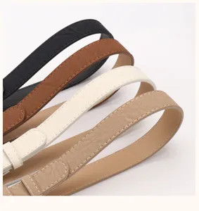 Detail view of four textured vintage faux leather belts in black, brown, cream, and khaki.