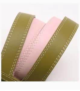 Close-up van olijfgroene en roze damesriem met opvallende witte stikseldetails