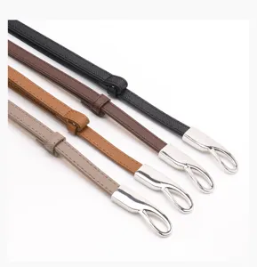 Detail view of slim leather belts featuring elegant silver buckles in four versatile colors