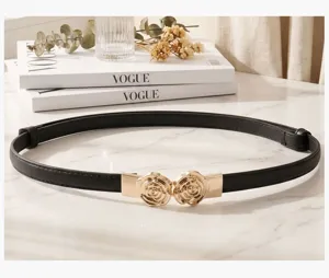 Dettaglio ravvicinato dell'elegante fibbia a rosa dorata su cintura in pelle nera vintage
