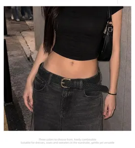 Detailed view of women's braided leather belt with stylish golden horseshoe buckle