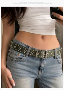 Close-up of olive green punk belt with silver rivets and grommets on jeans