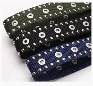 Close-up detail of punk style woven belts with double-row metal studs and eyelets.