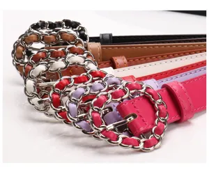 Detail of elegant women's belts with silver chain-link circular buckles in multiple colors.