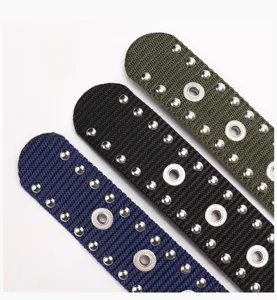 Close-up of punk style nylon belts featuring double row silver studs and metal eyelets.
