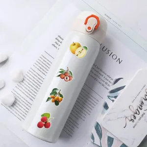 Primo piano di adesivi alla frutta su bottiglia bianca, materiale PET impermeabile.
