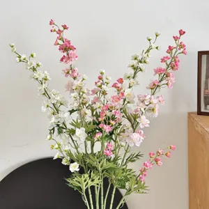 Detailed view of pink and white artificial larkspur flowers in a bright home setting