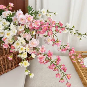 Close-up of pink and white artificial delphinium flowers arranged in a woven basket decor.
