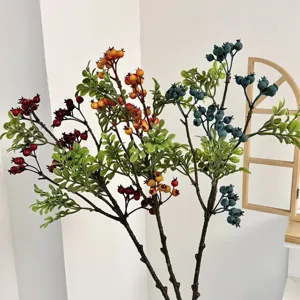 Close-up of decorative artificial berry branches with colorful blue, red, and orange fruits