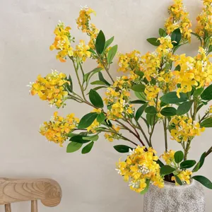 Close-up of vibrant yellow artificial lilac flowers in a stone vase for home decor