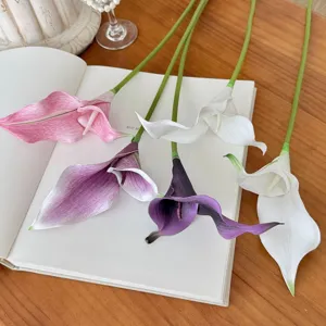 Primer plano de flores de cala artificiales de colores en un cuaderno de notas estético