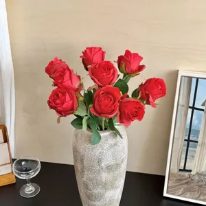 Elegant artificial red Bulgarian roses in a stone-textured vase for home decor setup.