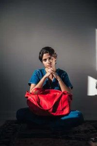Detalle de estilo de vida: bolso tote grande de cuero vintage rojo con modelo en denim