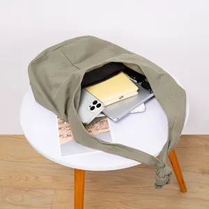 Detalle del bolso tote de lona verde oliva con gran capacidad de almacenamiento