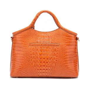 Detalle de bolso naranja vintage con textura de cocodrilo en relieve 3D y asa fija