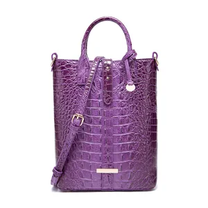 Vista detallada del patrón de cocodrilo en un bolso de mano vintage morado
