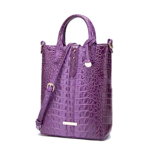 Vista detallada de bolso vintage morado con relieve de cocodrilo y oro.
