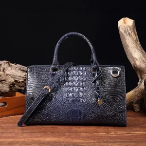 Elegante bolso de mano azul marino vintage con textura de cocodrilo y detalles dorados