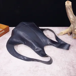 Vista detallada de una mochila vintage de cuero suave oscuro con forma de escarabajo