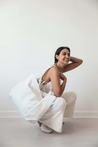 Vista de estilo de vida de mujer con un bolso tote grande blanco con bolsillo delantero