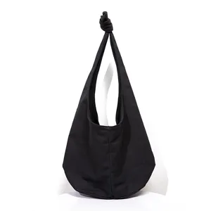 Bolso de hombro de lona negra con diseño de correa anudada para un look retro casual