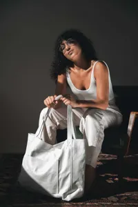 Detalle de un bolso tote grande blanco de cuero encerado con bolsillo en ambiente lifestyle