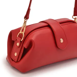Detailed close-up view of a retro red leather doctor bag with elegant gold hardware