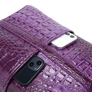 Detalle de bolsillos en bolso morado con relieve de cocodrilo y espacio para móvil.