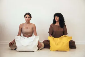 Modelos posando con grandes bolsos tote vintage blancos y amarillos con bolsillos frontales