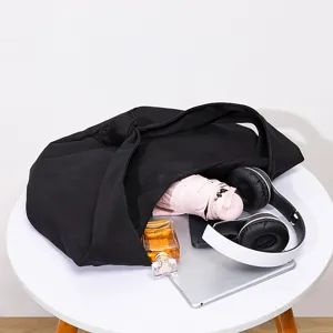 Bolso bandolera minimalista de lona negra con nudo y gran capacidad para uso diario.