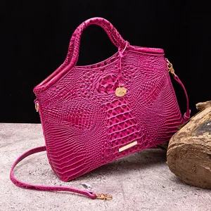 Vista detallada de la lujosa textura de cocodrilo fucsia en un bolso de cuero vintage.