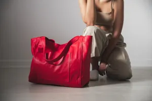 Bolso tote grande de cuero suave rojo con bolsillo en un entorno de estilo de vida