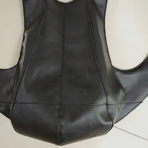 Vista detallada de las costuras finas y la textura de cuero mate de esta mochila escarabajo negra