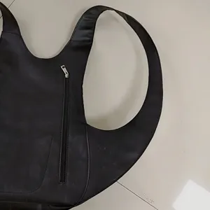 Detalle de mochila escarabajo retro con cuero negro suave y cremallera trasera.