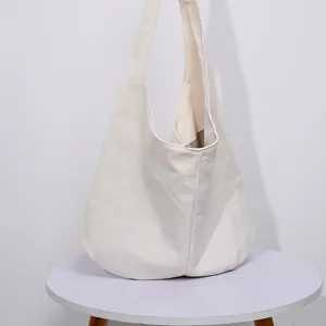 Vista lateral de bolso hobo vintage de lona de algodón y lino blanco para mujer