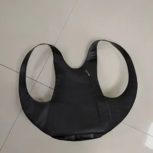 Mochila única de cuero negro con forma de escarabajo colocada sobre un suelo plano.