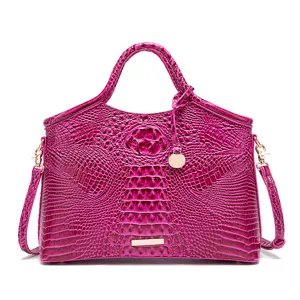 Detalle del bolso vintage fucsia con relieve de cocodrilo y herrajes dorados.