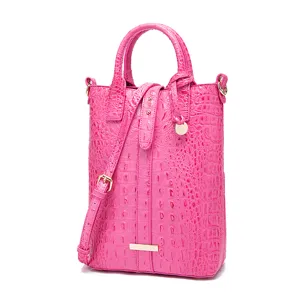 Primer plano detallado de un bolso rosa con relieve de cocodrilo y herrajes oro