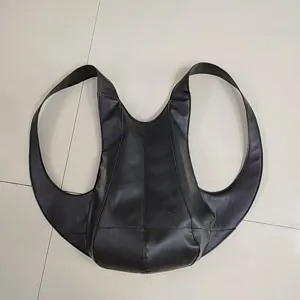 Vista detallada de una mochila negra con forma de escarabajo en cuero sintético suave