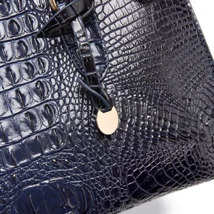 Primer plano detallado de la textura de cuero con relieve de cocodrilo azul marino de un bolso.