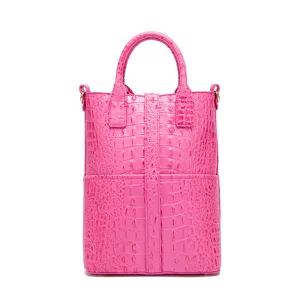 Bolso de mano fucsia vertical moderno con un patrón de cocodrilo en relieve sobre fondo blanco