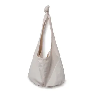 Vista detallada de la elegante correa anudada de este bolso hobo de lona de algodón.