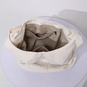 Vista interior detallada de un bolso de lona beige con bolsillos internos de cremallera y ranura