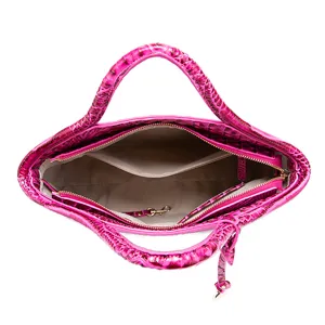 Vista interior detallada de bolso fucsia con relieve de cocodrilo y bolsillos.