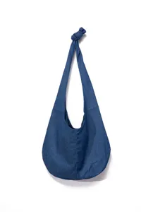 Vista detallada de un bolso de hombro de mezclilla azul vintage con asa anudada