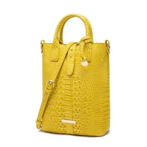 Bolso de mano vintage amarillo con textura de cocodrilo y detalles en dorado brillante